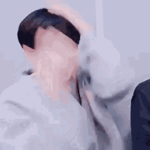 a close up of a person holding their hair in a room .