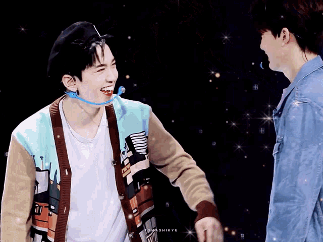 two young men are standing next to each other and one of them is wearing a sweater that says tokyo