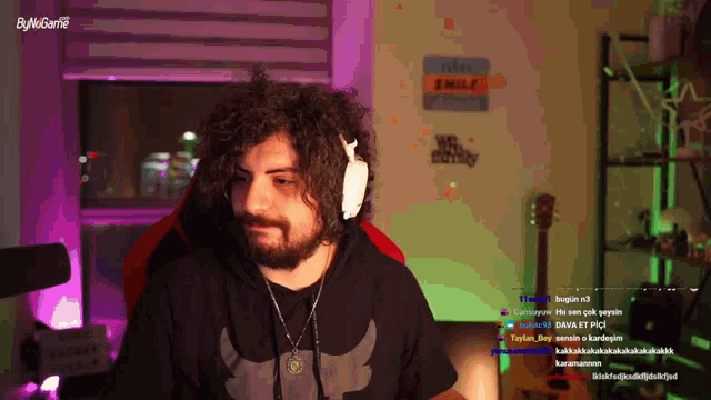a man wearing headphones is sitting in front of a sign that says smile on it