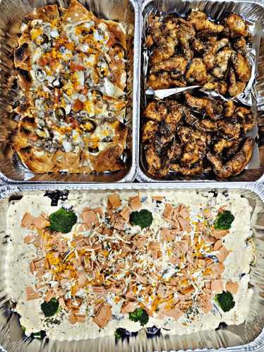 a tray of nachos chicken wings and a tray of broccoli cheese dip