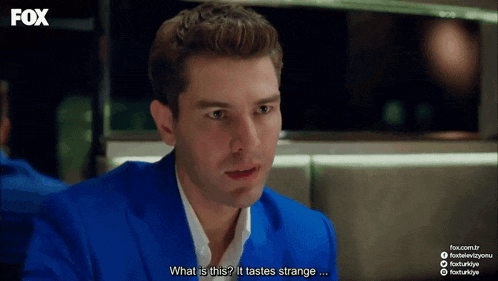 a man in a blue suit says " what is this ? it tastes strange ... "