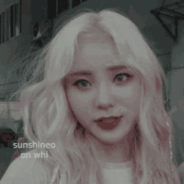 a close up of a girl with blonde hair and red lips .