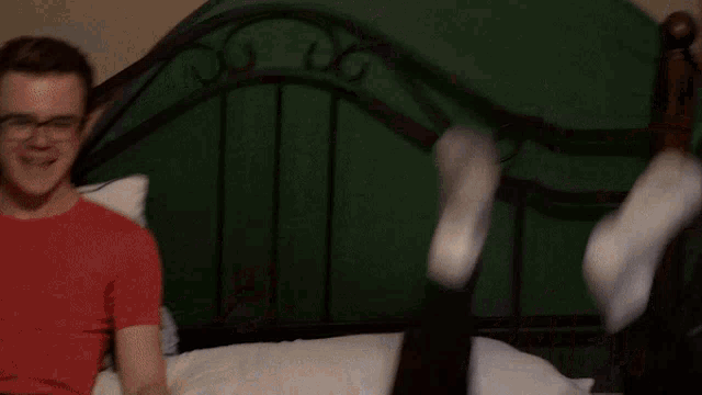 a person is laying on their stomach with their feet up on a bed .