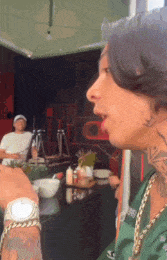 a man with a tattoo on his neck is wearing a watch and chains