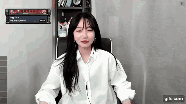 a woman in a white shirt is sitting in a chair with her eyes closed