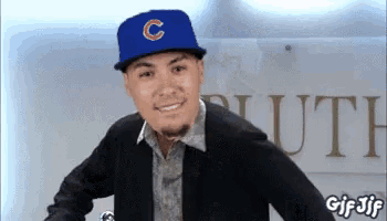 a man wearing a blue hat with a c on it