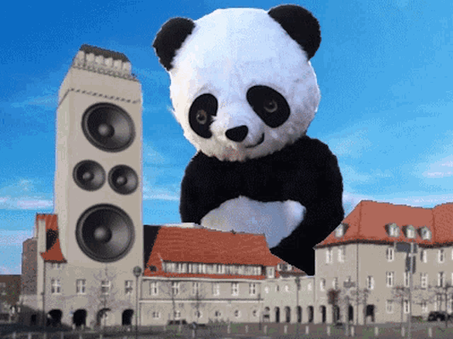 a giant panda bear is standing in front of a large speaker
