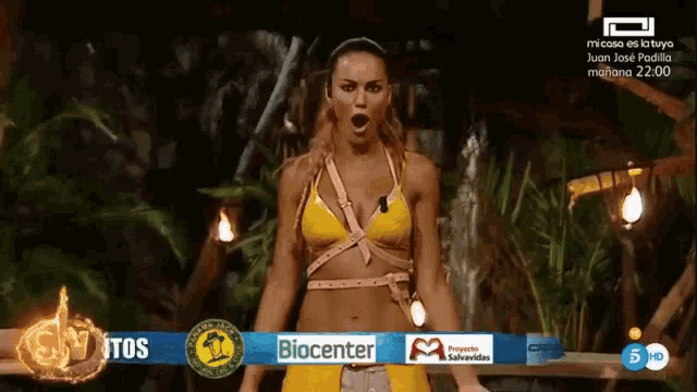 a woman in a yellow bikini is standing in front of a banner that says biocenter