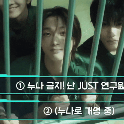 a man in a green shirt is behind bars with chinese writing on it