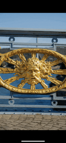 a gold statue of a man with a beard is on a fence