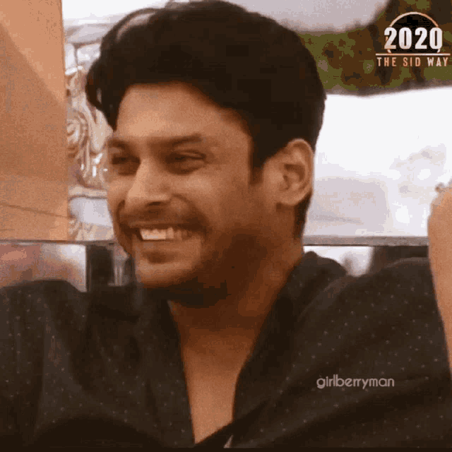 a man is smiling in front of a sign that says ' 2020 the side '