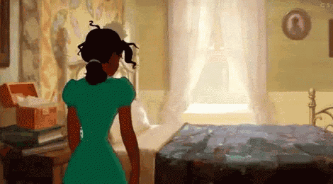 a woman in a green dress is standing next to a bed in a room .