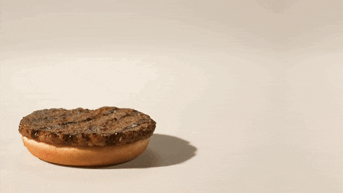 two hamburgers with lettuce and tomatoes on them