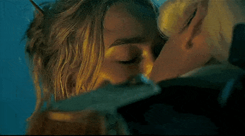 a close up of a woman kissing a man on the cheek .