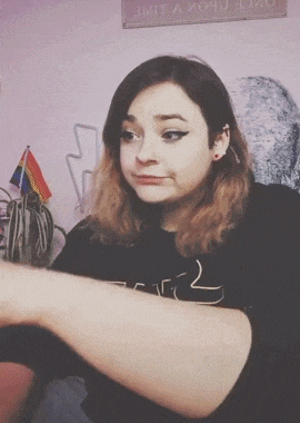a woman wearing a black star wars shirt is holding a bag of chips