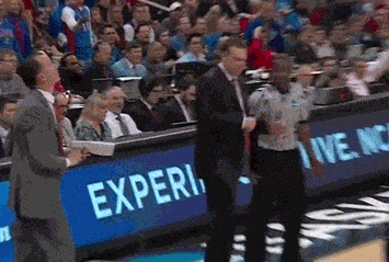 a man in a suit stands in front of a blue sign that says experi