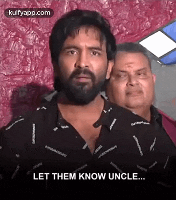 a man with a beard is standing next to another man and says `` let them know uncle ... '' .