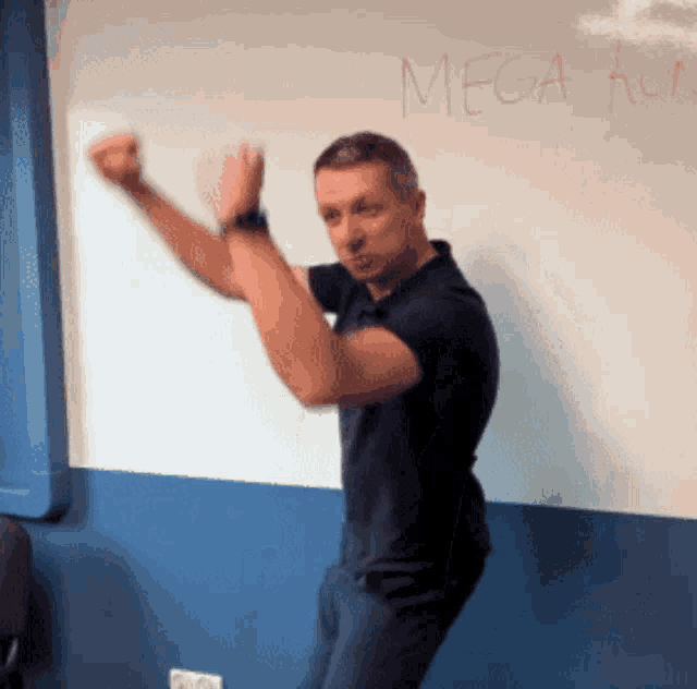 a man stands in front of a whiteboard that says mega ko