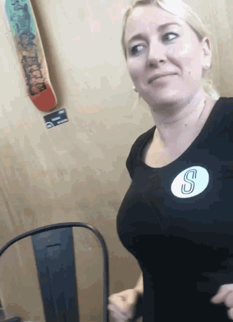 a woman wearing a black shirt with the letter s on her chest