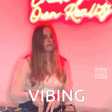 a woman in front of a neon sign that says " vibing "