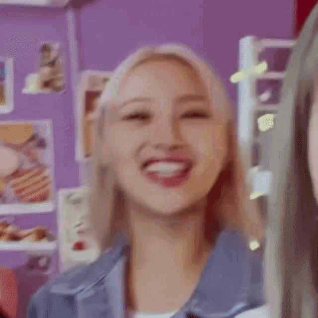 a close up of a woman laughing in a room with a purple wall .