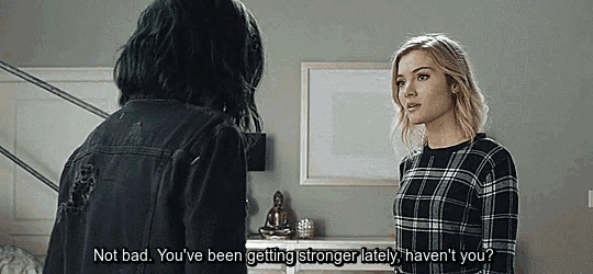 two women are standing next to each other in a room and one of them is talking to the other .
