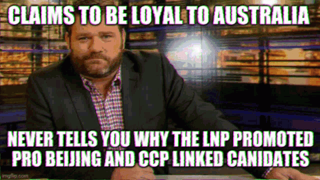 a man in a suit and plaid shirt is sitting at a desk and claims to be loyal to australia ..