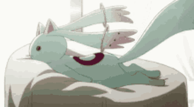 a cartoon cat with wings is laying on a cushion on a bed .