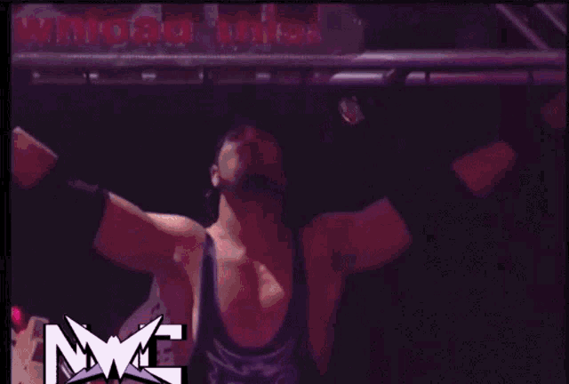 a wrestler with his arms outstretched in front of a raw logo