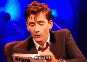 a man in a suit and tie is holding a piece of paper that says " correct "