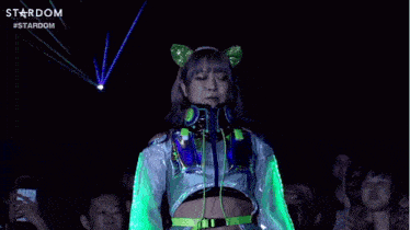 a woman in a futuristic outfit is dancing in front of a crowd in a club .