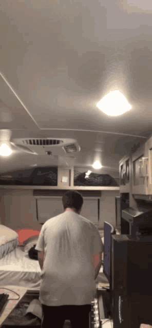 a man in a white shirt is standing in a room