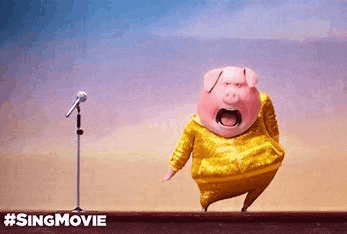 a pig is singing into a microphone in front of a crowd .