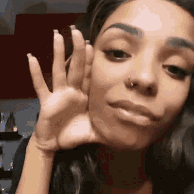 a woman with a nose ring is making a funny face