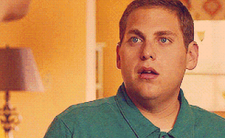 a man in a green shirt is looking surprised