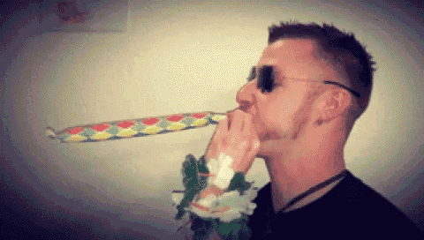 a man wearing sunglasses is blowing a party horn in his mouth