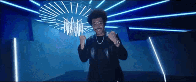a man in a black jacket is dancing in a dark room