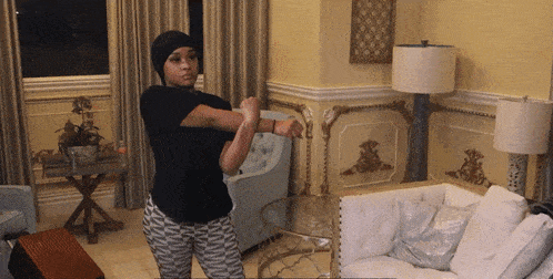 a woman is stretching her arms in front of a white couch