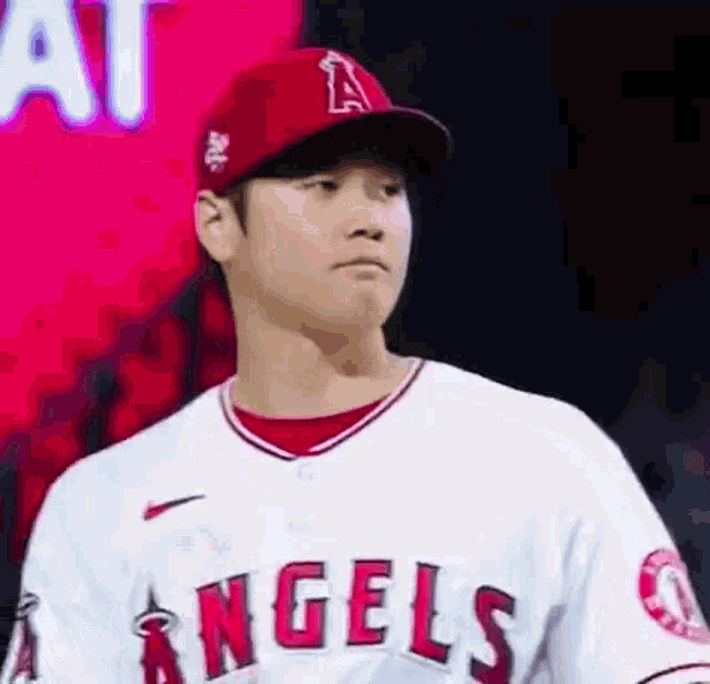 a close up of a baseball player wearing a red hat and a white uniform .