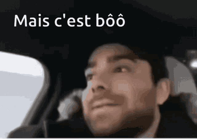 a man sitting in a car with the words mais c'est boo written above him