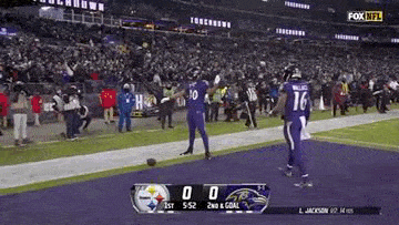 a football game is being played on a field with a scoreboard .