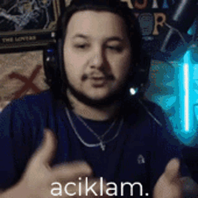 a man wearing headphones and a necklace says aciklam .