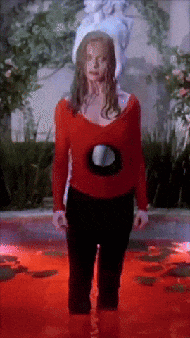 a woman in a red top and black pants stands in a pool of blood