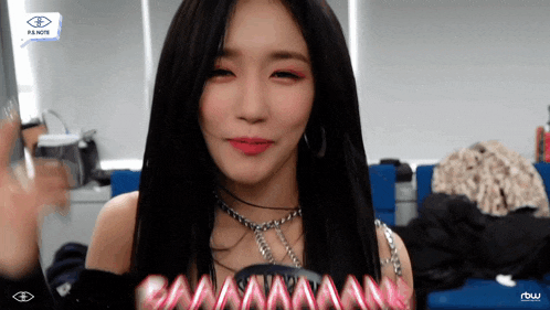 a woman with long black hair is wearing a necklace and earrings ..