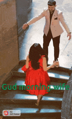a woman in a red dress is walking down stairs with a man