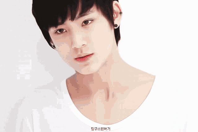 a close up of a young man 's face with korean writing on the collar