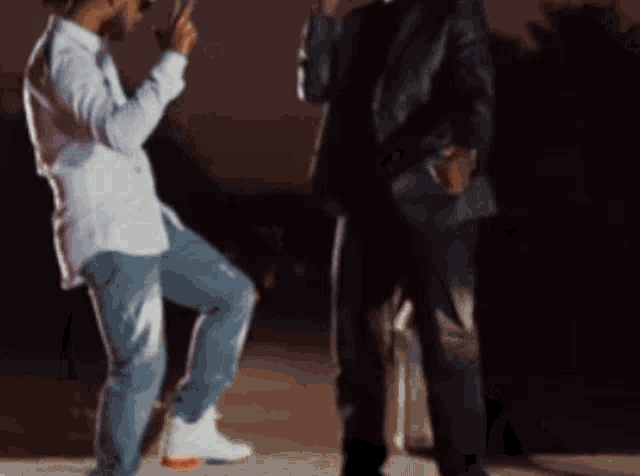 two men are standing next to each other in the dark