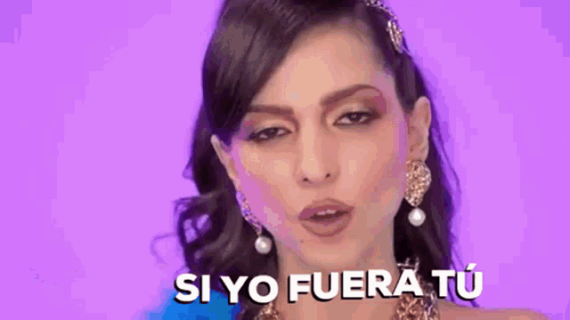 a woman wearing earrings and a headband is making a funny face .