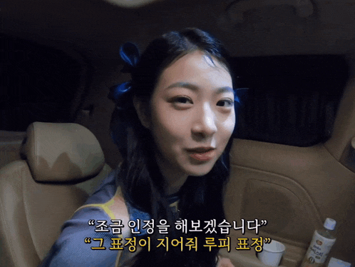 a woman sitting in the back seat of a car with korean writing on the back