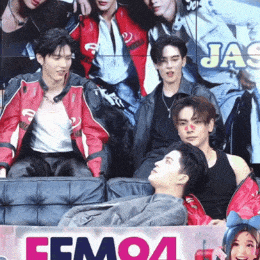 a group of people sitting in front of a sign that says femoa